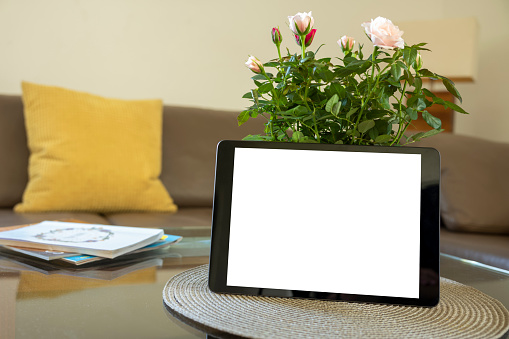 Modern tablet on a desk at home white screen template.