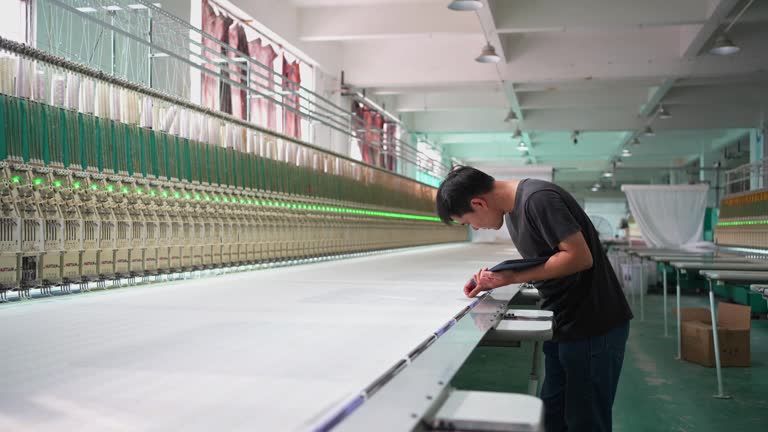 Workers inspecting knitting machines