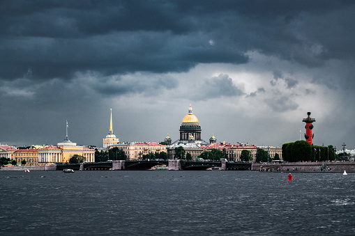 Saint Isaac's Cathedral and Spit of Vasilievsky Island seen from Neva river. Dramatic rainy clouds on the background. St. Petersburg