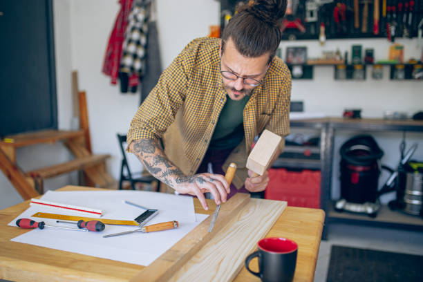 istock Young craftsman chiseling a wooden plank 1678243368