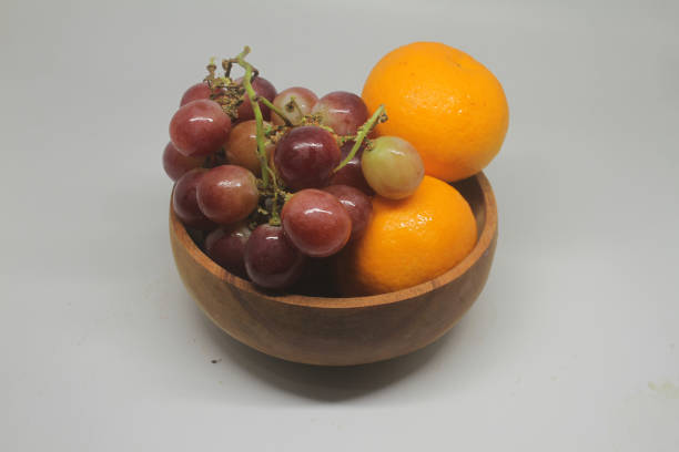 istock grapes and oranges on a wooden bowl 1678260257