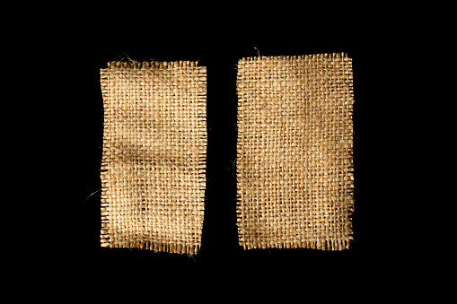 Two pieces of burlap isolated on a black background.