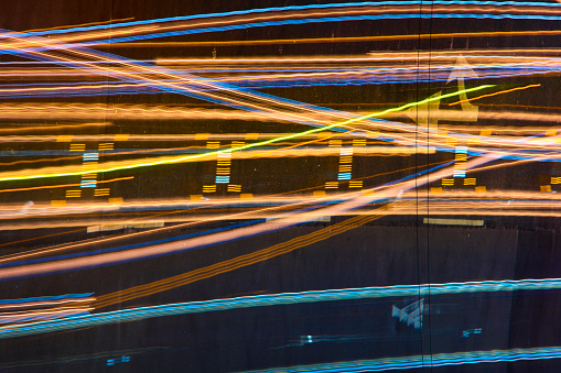 Long exposure shoot of traffic trail lighting at night in Taipei Taiwan. It makes so many abstractive color lines on the road. Top view of motion speed light in the rush hour. Including cars and motorcycles. It has multiple color and cyberpunk style.