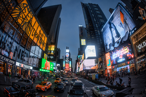 An evening glimpse at Times Square in New York City, with all its advertisement and people walking around.