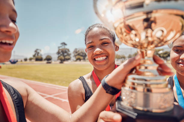 istock Winner, trophy and track team celebrate olympic relay teamwork, sprint competition or marathon race victory. Award, goal achievement and success celebration for athlete friends, runner or black women 1678322479