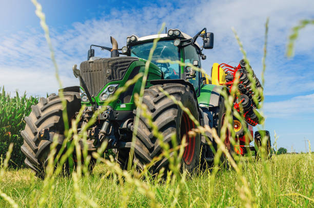 istock Creative agricultural landscape. Low angle view through grass to tractor with a field drill. 1678341826