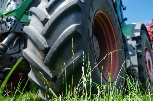 istock Low angle view through grass to tractor wheel. Agricultural landscape. 1678352249