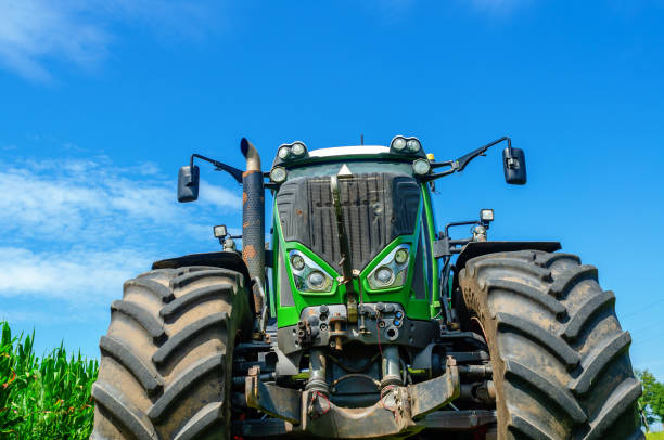 istock Large tractor on a summer field. Front view. Blue sky in the background. 1678353351