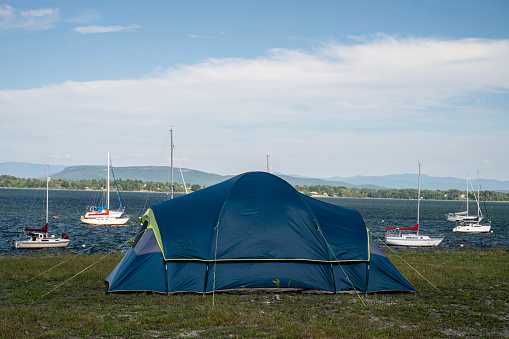 Tent at a campsite by Lake Champlain with sailboats at anchor