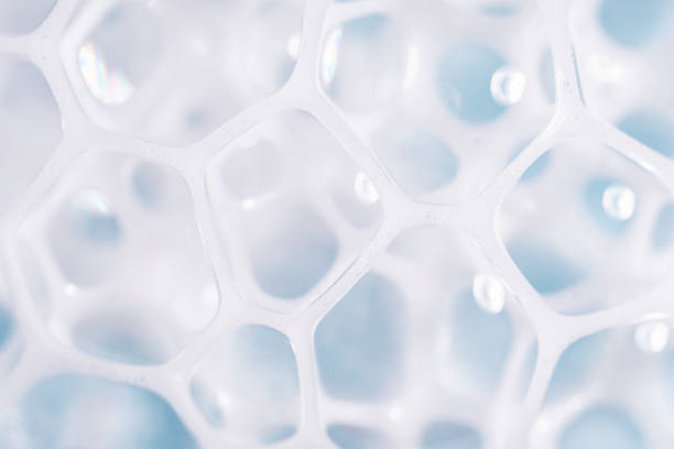 istock Foam texture on blue background, macro. Soap, shampoo, shower gel foam, face cleansing mousse or bubble mask sample. White cleanser foam bubbles on blue background. 1678391791