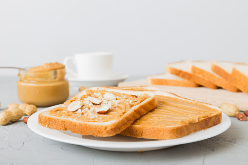 Peanut butter sandwiches or toasts on light table background.Breakfast. Vegetarian food. American cuisine top view vith copy space.