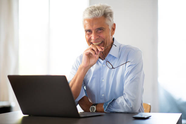 istock smiling businessman sitting at office desk 1678427785