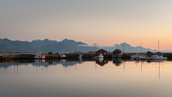 Harbour with boats at sunset and mountain background, Lofoten Islands, Norway