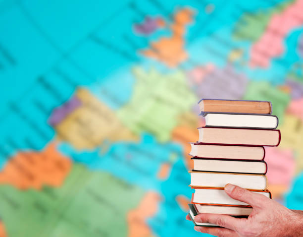 istock hands with stacked books and geographic map 1678471276
