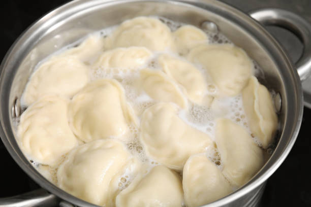 istock Boiling delicious dumplings (varenyky) in pot, closeup 1678475159