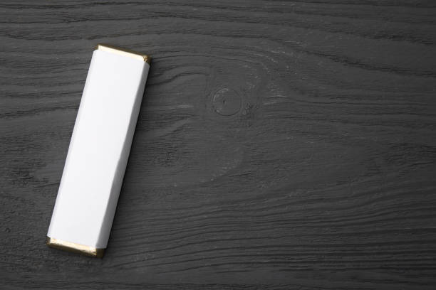 istock Tasty chocolate bar in package on grey wooden table, top view. Space for text 1678475474