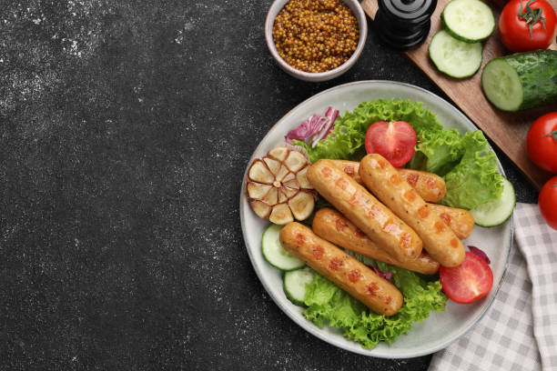 Delicious grilled vegan sausages with fresh herbs and vegetables on grey table, flat lay. Space for text