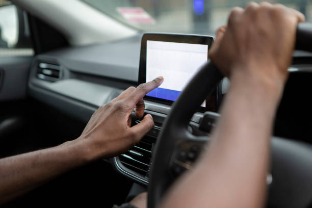 istock Close-up of hands using a touchscreen in a car 1678478814