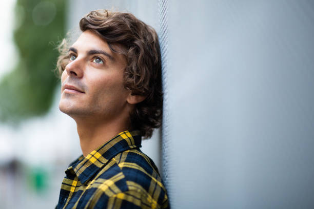 istock Thoughtful young man leaning to gray wall 1678479490