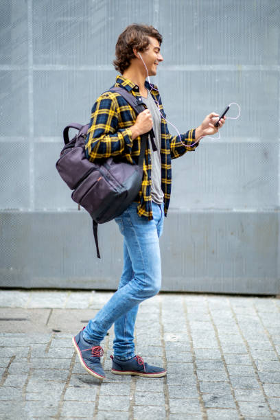 istock Happy young man walking with cellphone and earphones 1678480055
