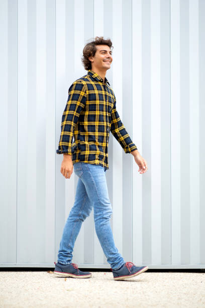 istock Happy young man walking outside and smiling 1678481699