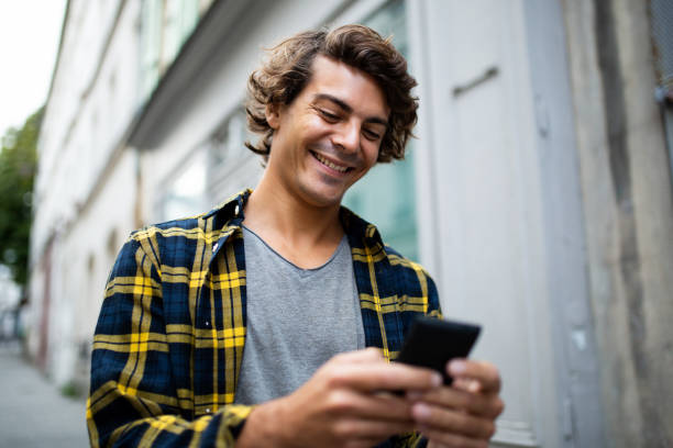 istock Handsome young man using mobile phone walking outside in the city 1678482876