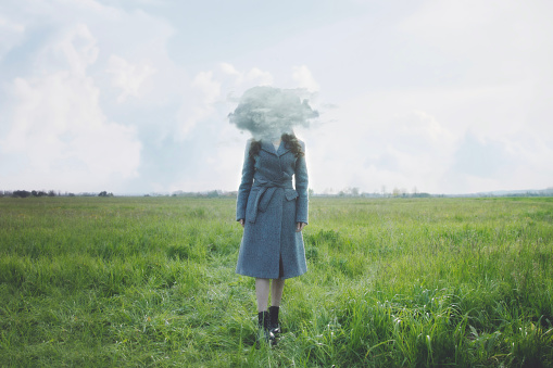 surreal cloud flies in front of a woman's face hiding her, abstract concept