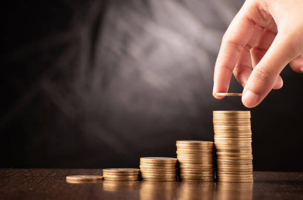 istock Putting coin in stack investing in business 1678497177