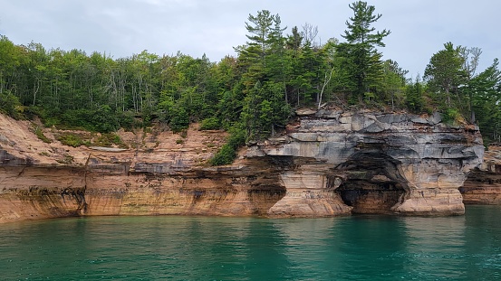 Hundreds feet high cliffs of the Pictured Rocks National Lake shore, Michigan, USA. These colorful, sandstone cliffs have been carved  by water and wind erosion along the southern shore of the Lake Superior. Picture taken near the Grand Portal.
