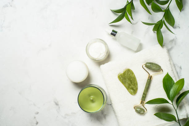 istock Jade roller and gua sha stone massager with face cream and serum bottle. 1678504372