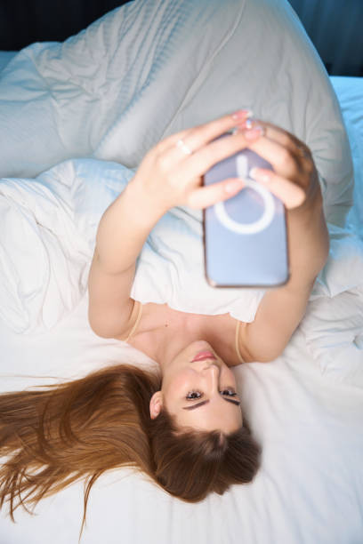 istock Attractive female using cell phone in modern room 1678554861