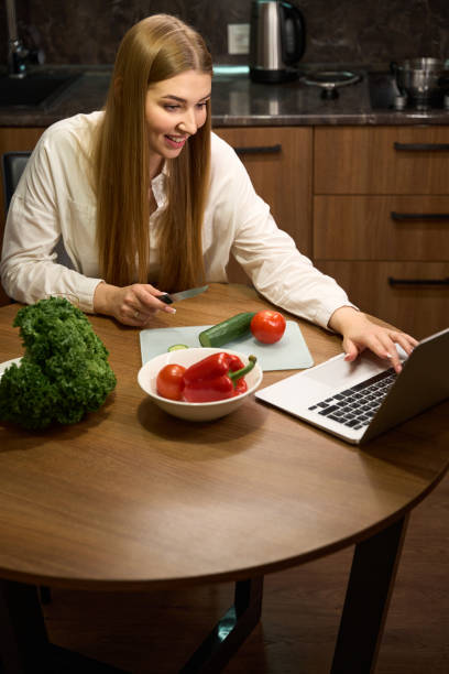 istock Attractive female making salat in modern kitchen 1678558202