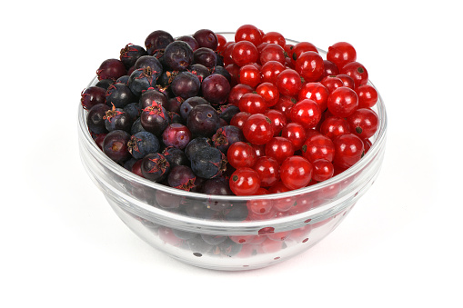 Berries of amelanchier and red currant on glass bowl. High resolution photo. Full depth of field.