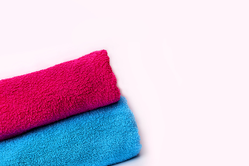 Blue and pink towel on a white background. folded fresh towels close-up. sauna spa treatments