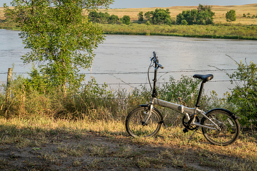 Halsey, NE, USA - September 9, 2023: A lightweight, folding bike, Dahon Mariner D8, on a shore of Dismal River in Whitetail Campground in Nebraska National Forest.
