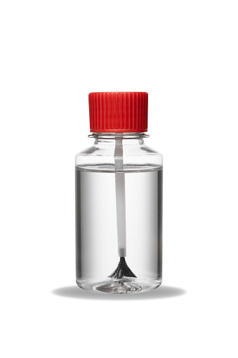 Glass chemistry bottle with transparent liquid or solvent used for label cleaning on white background. A science lab equipment for lab testing and experiment. With shadow.