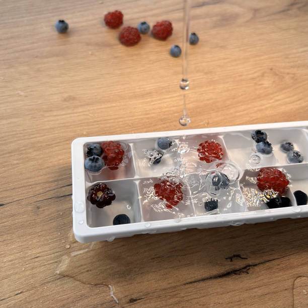 istock Freezing raspberries in water. Fruit ice. White plastic ice mold. 1678649889