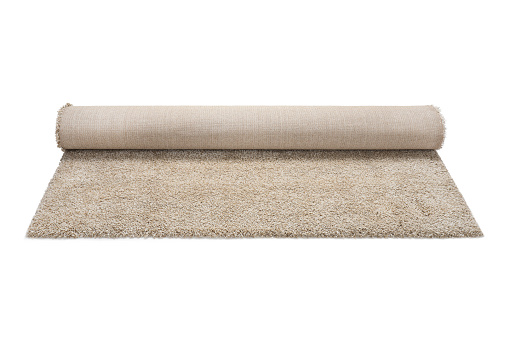 Rolled fuzzy carpet on white background. Interior element