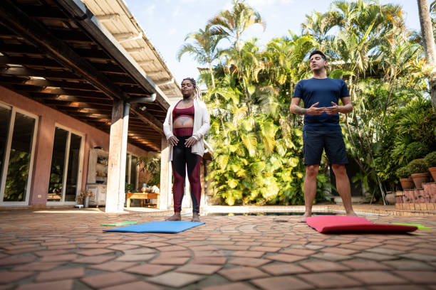 Pregnant couple doing yoga at home