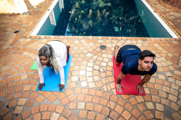 istock Couple doing yoga at home 1678733728