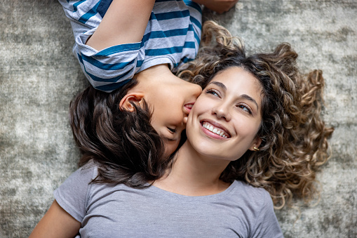 Happy family on a summer meadow. little girl child baby daughter hugging and kissing mother