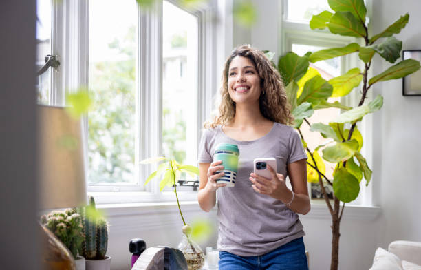 istock Happy woman at home checking her cell phone while drinking coffee 1678740848