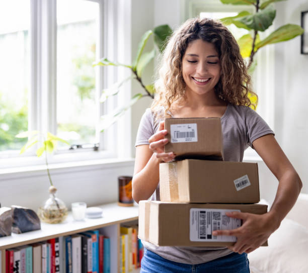 istock Woman at home receiving a package in the mail 1678741382