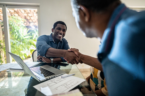 Architect handshaking with a customer at home