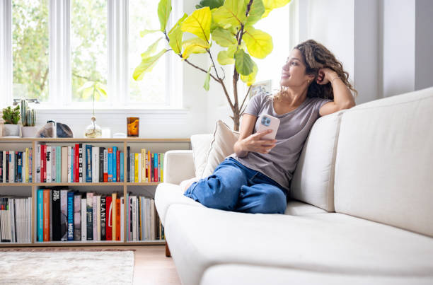 istock Happy woman relaxing at home using her cell phone 1678741390