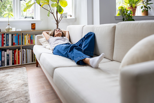 Casual woman relaxing at home lying on the sofa - domestic life concepts