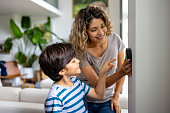 Mother and son at home using a smart thermostat