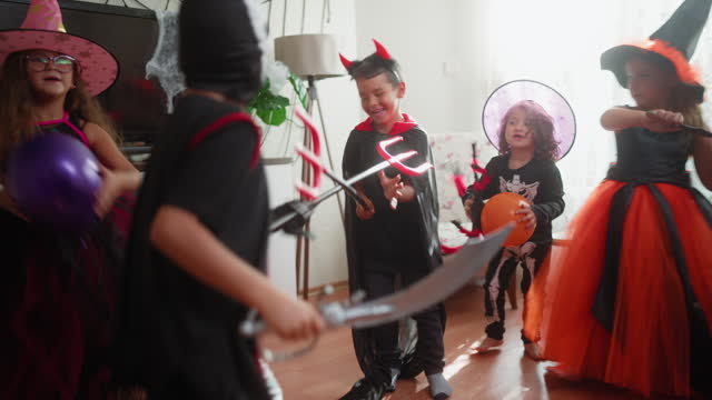 Children gathering together for Halloween party at home and playing games in living room