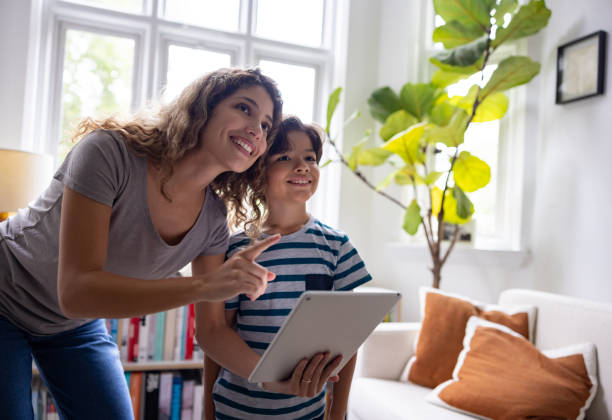 Mother and son controlling her smart home on a digital tablet