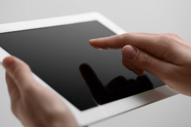 istock Closeup view of woman using modern tablet on light grey background 1678754011